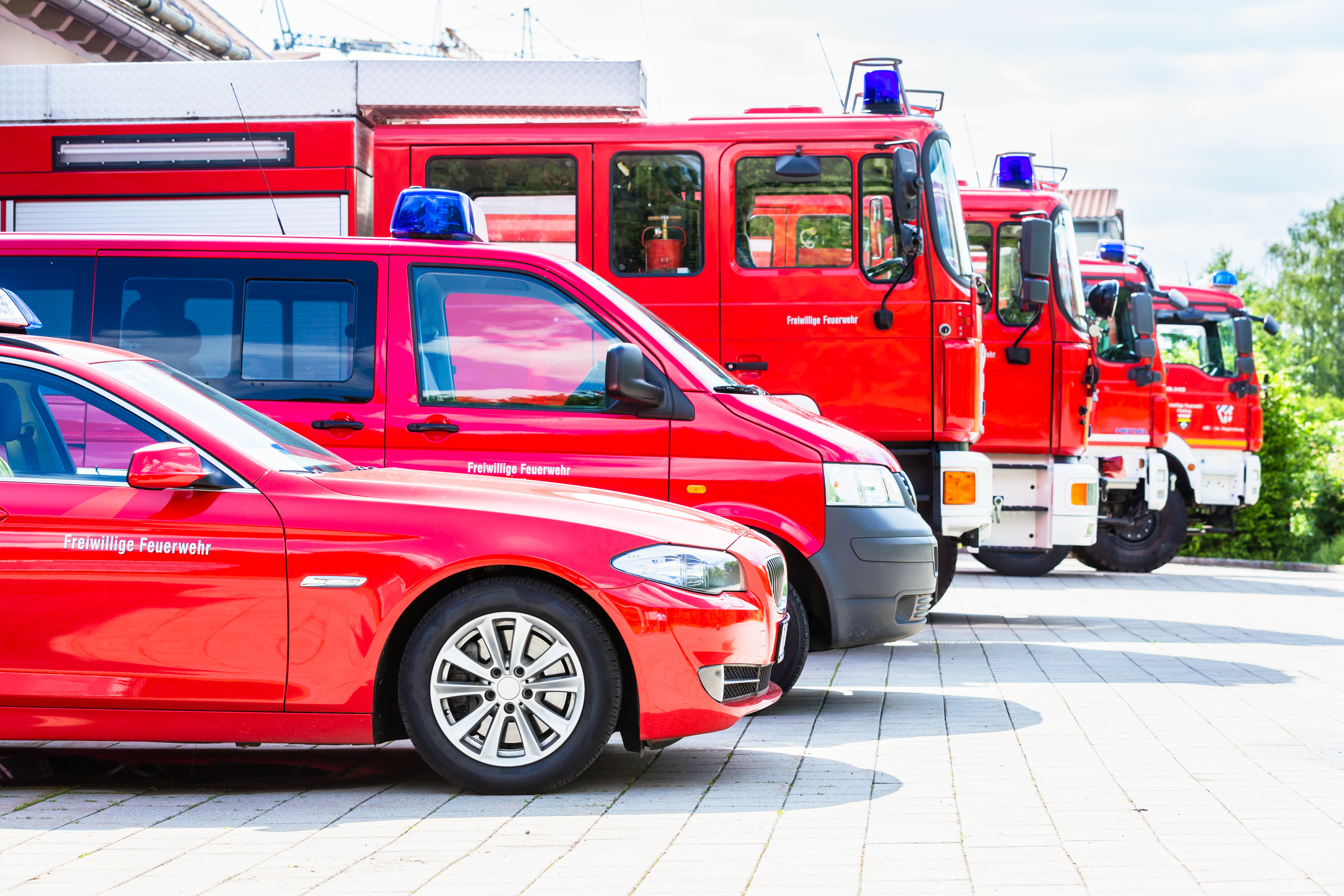 Eine Reihe verschiedener Feuerwehr-Fahrzeuge von der Seite aufgenommen.