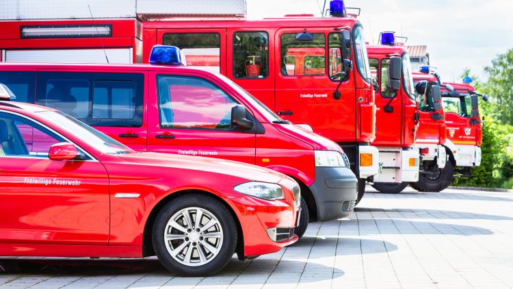 Eine Reihe verschiedener Feuerwehr-Fahrzeuge von der Seite aufgenommen.