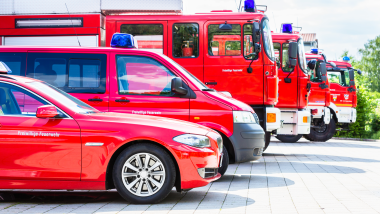 Eine Reihe verschiedener Feuerwehr-Fahrzeuge von der Seite aufgenommen.